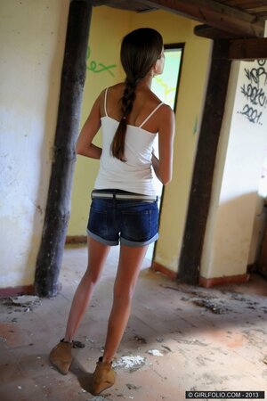 Skinny lassie spreads legs revealing trimmed pussy in the abandoned building