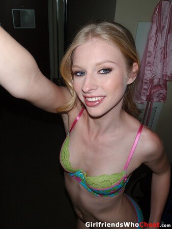 Tempting blonde doll with small tits undresses to pose for nude photos