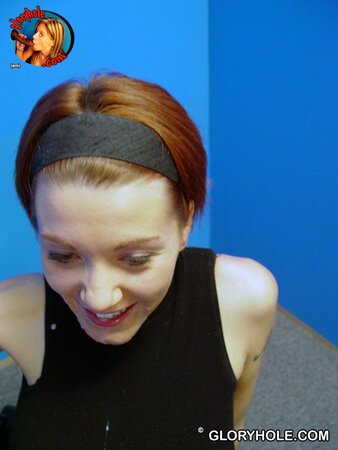 Pretty redhead stands on her knees to blow black cock in a gloryhole room