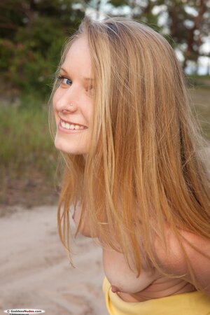 Charming blond lassie pulls off clothes to display her yummy naked body outdoors