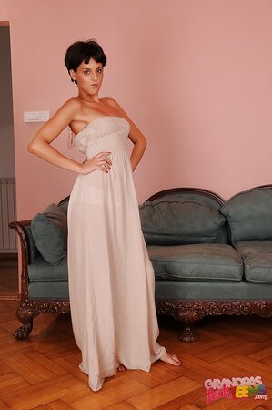 Flirty short-haired babe doffs long dress to tease with her young naked body