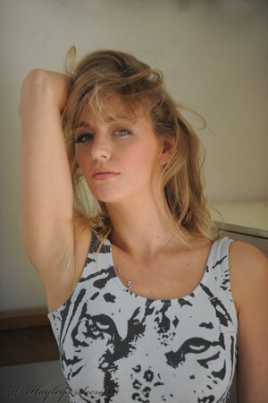 Hot blond lassie sensually poses by the mirror and reveals perky tits