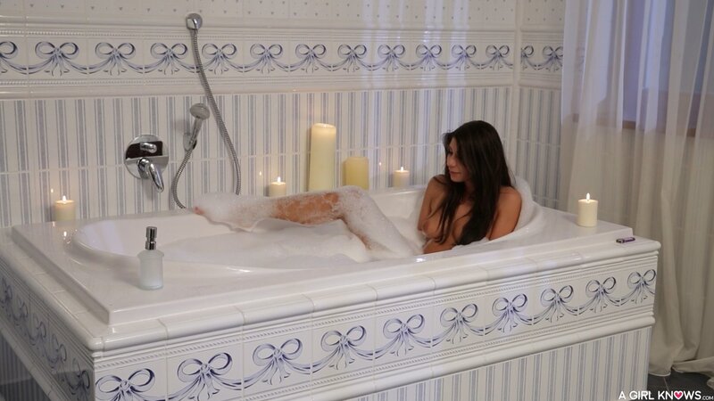 Brunette is going to pet her pussy while taking a warm bath