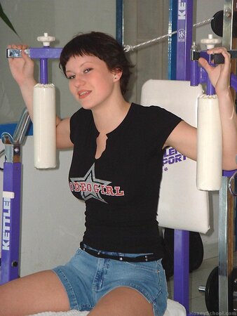 Hottie with short hair working out in the gym before stripping