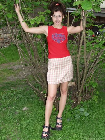 Young girl with a nice smile is outdoors and fingers herself