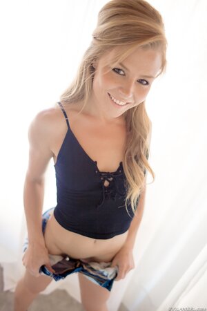 Petite sweetie poses in denim shorts then pulls them down to spread pussy