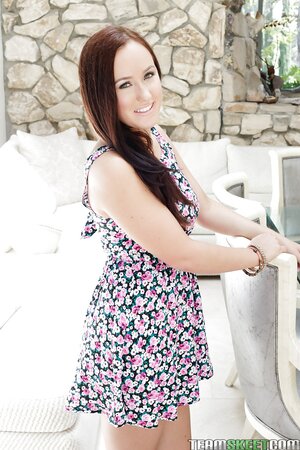 Young girl with cute smile enters the house and takes off light summer dress