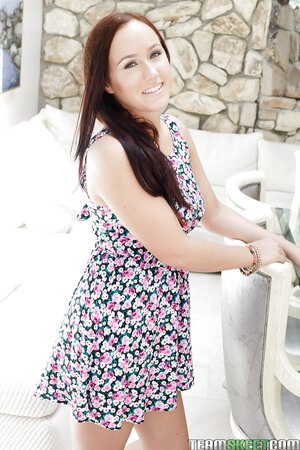 Young girl with cute smile enters the house and takes off light summer dress
