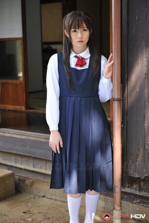 Innocent Japanese schoolgirl with beautiful eyes walks seductively under sun
