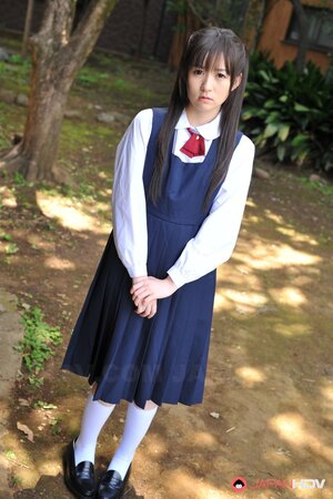 Innocent Japanese schoolgirl with beautiful eyes walks seductively under sun