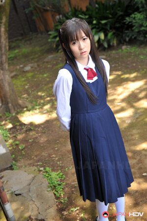 Innocent Japanese schoolgirl with beautiful eyes walks seductively under sun