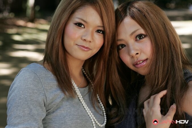 Excited Japanese girlfriends make out during promenade on city streets