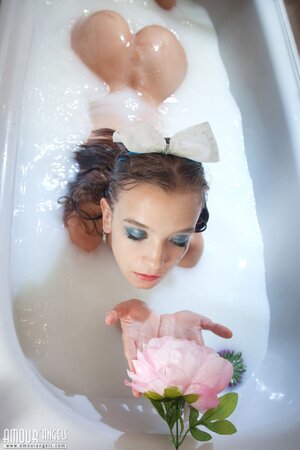 Alisabelle pours milk over her naked body in the bath