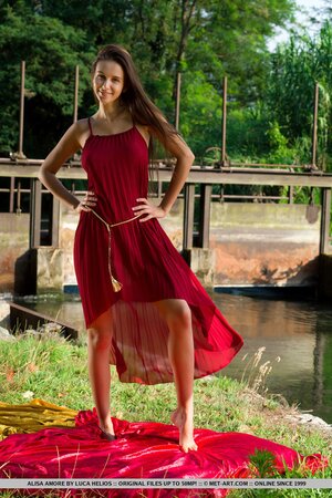 Alisa Amore disrobes to pose naked near a dam