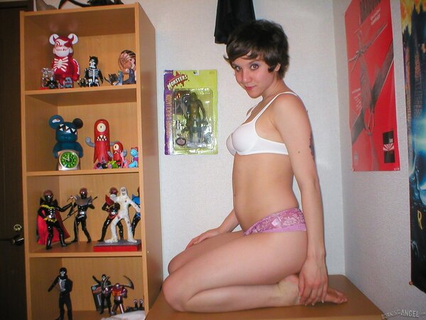 Schoolgirl with small boobs is posing for XXX pics in the bedroom