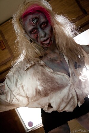 Horny zombie with big tits tears off her clothes in fetish pics
