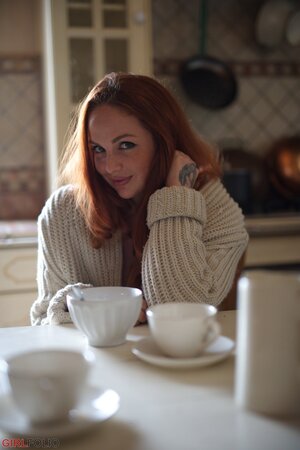 UK redhead Kara Carter enjoys rubbing cream into her big natural tits in the kitchen
