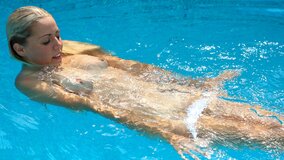 Small titted blonde spreads and fingers pussy poolside