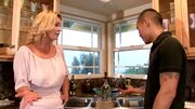 A blonde milf is getting her pussy spread open in the kitchen