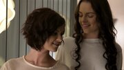 Two black haired girls are touching and teasing one another